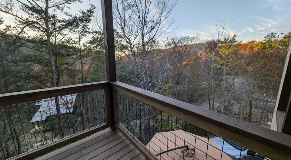 Ridgeline view over autumn treetops from the balcony rail